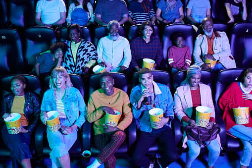 An audience of cinema goers enjoying popcorn - can you guess which of them is called Elizabeth? (Credit: Getty Images) 