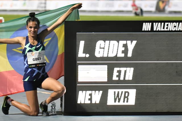 Ethiopian athlete Letesenbet Gidey waves an Ethiopian national flag as she celebrates after breaking the 5,000m world record during the NN Valencia World Record Day at the Turia stadium in Valencia on October 7, 2020