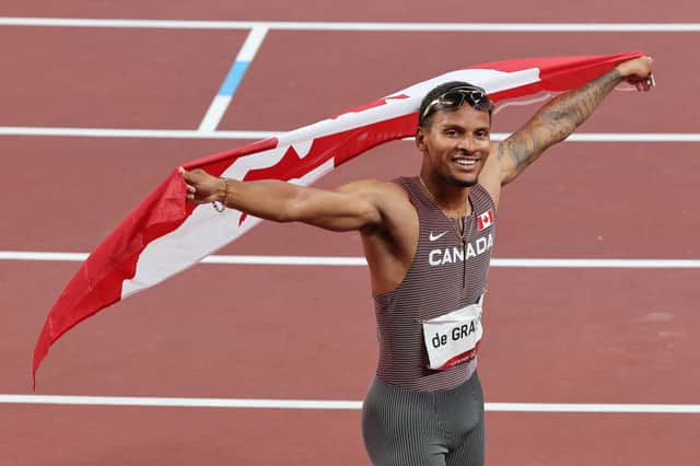 Andre De Grasse celebrates with the Canadian national flag after winning the men's 200m final during the Tokyo 2020 Olympic Games (Photo by GIUSEPPE CACACE/AFP via Getty Images)