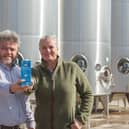 Philip and Rebecca Rayner of Glebe Farm Foods with a bottle of their PureOaty milk on their Cambridgeshire farm