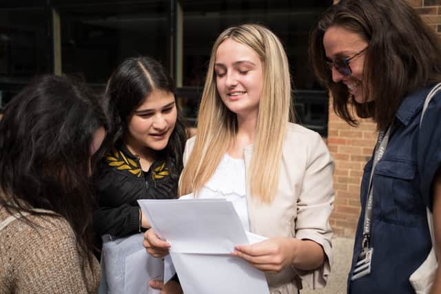 A student is congratulated by friends as as she receives her GCSE exam results  (Photo by Leon Neal/Getty Images)