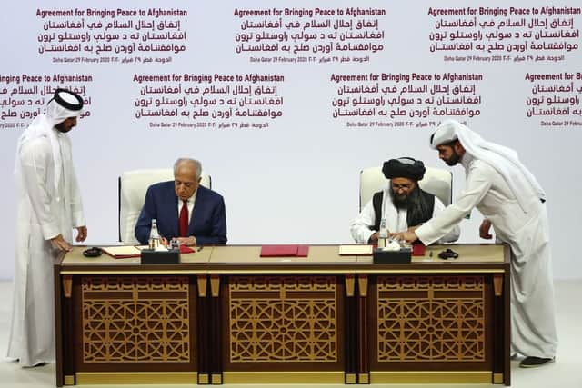 US Special Representative for Afghanistan Reconciliation Zalmay Khalilzad and Taliban co-founder Mullah Abdul Ghani Baradar sign a peace agreement during a ceremony in the Qatari capital Doha (Photo: KARIM JAAFAR/AFP via Getty Images)