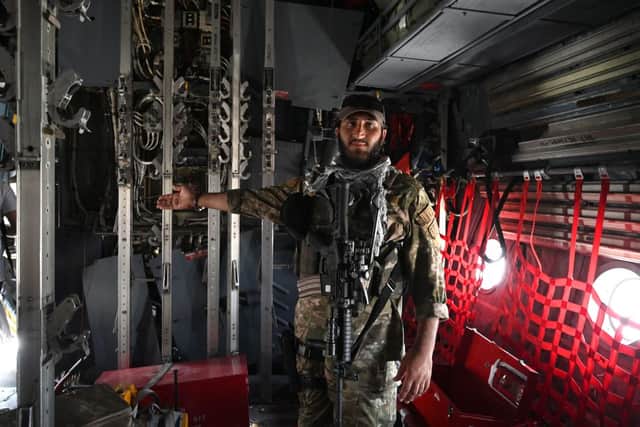 A Taliban Badri special force fighter gestures inside an Afghan Air Force aircraft at the airport in Kabul (Photo: WAKIL KOHSAR/AFP via Getty Images)
