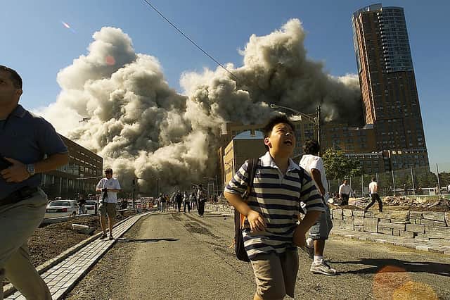 People run away as the second tower of World Trade Centre crumbles down after a plane hit the building 11 September 2001 (Photo: Jose Jimenez/Primera Hora/Getty Images)