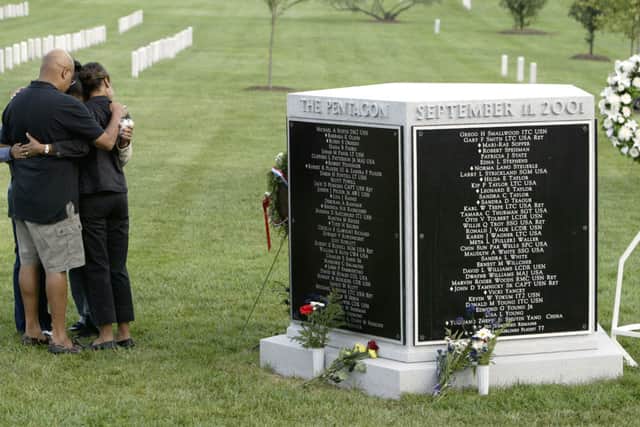 Unidentified family members of the 9/11 attack on the Pentagon embrace at the September 11th Memorial Marker in Arlington National Cemetery (Photo: Matthew Cavanaugh/Getty Images)