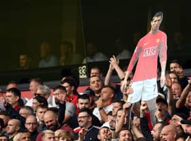 A cardboard cut out of new signing Cristiano Ronaldo is held by Manchester United supporters during the English Premier League football match between Wolverhampton Wanderers and Manchester United at the Molineux stadium in Wolverhampton, central England on August 29, 2021.  