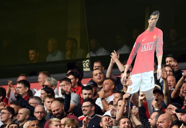 <p>A cardboard cut out of new signing Cristiano Ronaldo is held by Manchester United supporters during the English Premier League football match between Wolverhampton Wanderers and Manchester United at the Molineux stadium in Wolverhampton, central England on August 29, 2021.  </p>