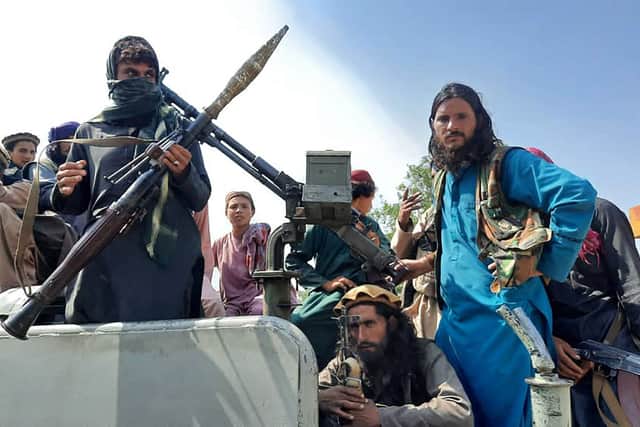 Taliban fighters sit over a vehicle on a street in Laghman province (Photo: -/AFP via Getty Images)