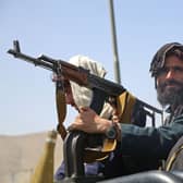 Taliban fighters stand guard in a vehicle along the roadside in Kabul (Photo: -/AFP via Getty Images)