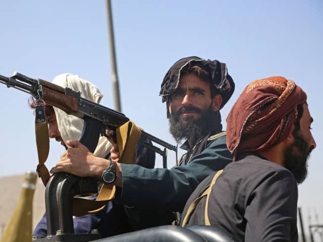 Taliban fighters stand guard in a vehicle along the roadside in Kabul (Photo: -/AFP via Getty Images)