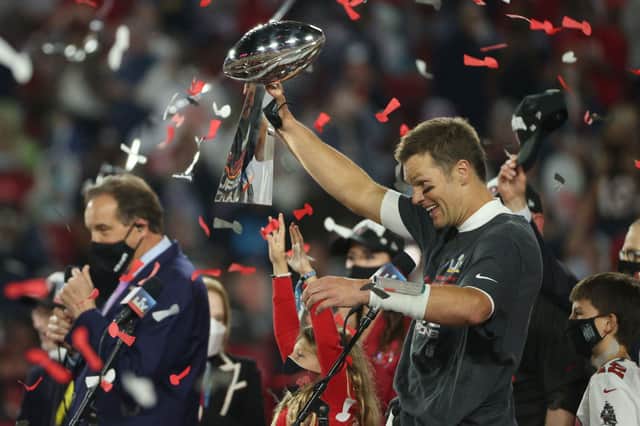 Tom Brady of the Tampa Bay Buccaneers hoists the Vince Lombardi Trophy after winning Super Bowl LV for a record seventh time.
