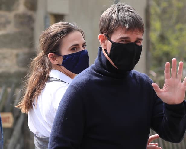 Tom Cruise waves to onlookers as he walks to set in the village of Levisham in the North York Moors (Photo: PA)