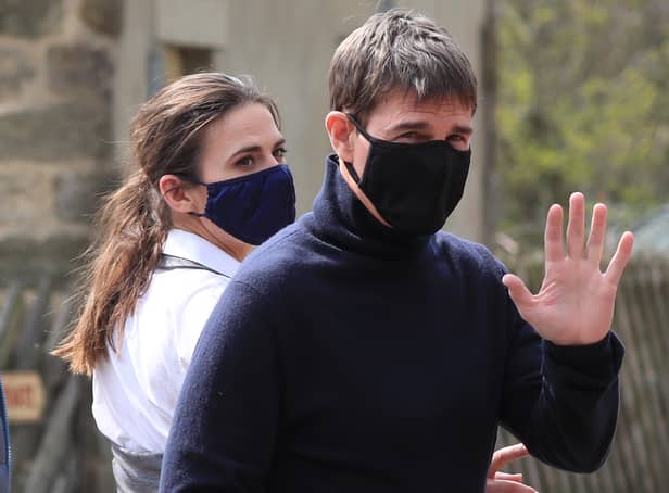 Tom Cruise waves to onlookers as he walks to set in the village of Levisham in the North York Moors (Photo: PA)