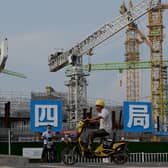 Workers drive their motorbikes in front of the under-construction Guangzhou Evergrande football stadium in Guangzhou, China’s southern Guangdong province on September 17, 2021. (Pic: Getty)
