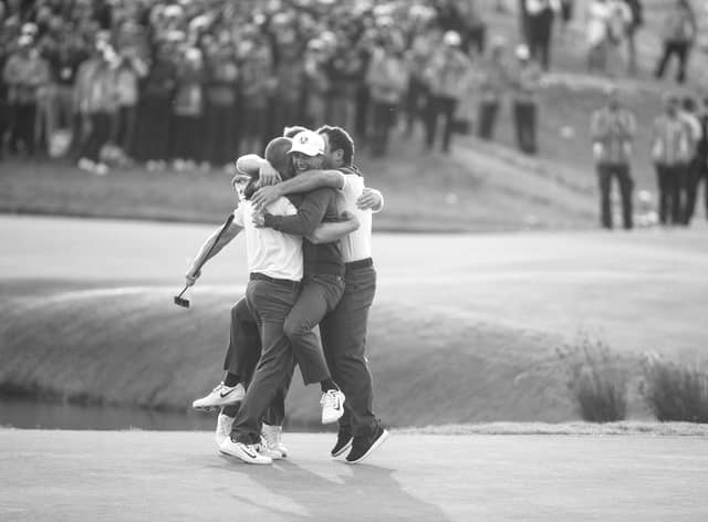 Alex Noren is congratulated by Thorbjorn Olsen, Tyrrell Hatton and Francesco Molinari as he wins on the 18th green during singles matches of the 2018 Ryder Cup at Le Golf National on September 30, 2018 in Paris, France. (Photo by Richard Heathcote/Getty Images)