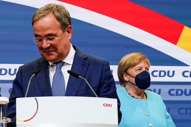 Armin Laschet speaks at a CDU election event as outgoing Chancellor Angela Merkel looks on.