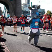 A Runner wearing fancy dress crossing Tower Bridge at 2021 London Marathon. The Ballot is now open for the event in 2022. 