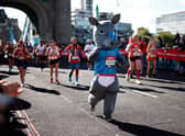 A Runner wearing fancy dress crossing Tower Bridge at 2021 London Marathon. The Ballot is now open for the event in 2022. 
