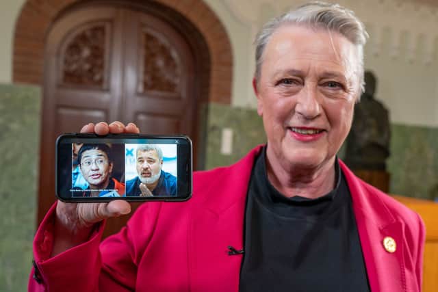 Berit Reiss-Andersen, chair of the Nobel Peace Prize Committee, presents a mobile phone displaying a combination of pictures of journalists Maria Ressa and Dmitry Muratov following the announcement. 