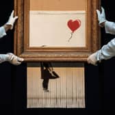 Sotheby’s employees pose with ‘Love is in the Bin’ by British artist Banksy (Photo: Jack Taylor/Getty Images)