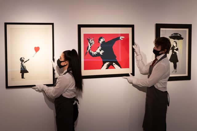 Girl with Balloon, Love is in the Air and NOLA (Yellow Rain) by Banksy are displayed during preparations ahead of online sales at Christies Auction House (Photo: Ian Gavan/Getty Images)
