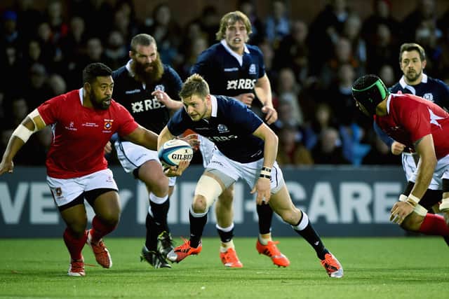 Finn Russell of Scotland tackle by Tukulua Lokotui and Elvis Taione of Tonga during the autumn test international match at Rugby Park on November 22, 2014 in Kilmarnock, Scotland