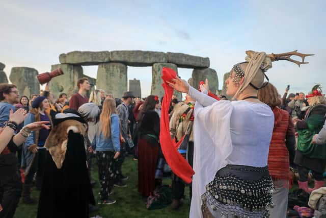 People dance as druids, pagans and revellers gather at Stonehenge, hoping to see the sun rise, as they take part in a winter solstice ceremony (Photo: Matt Cardy/Getty Images)