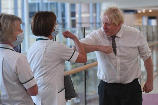 A maskless Boris Johnson greets nurses at Hexham General Hospital in Northumberland during a visit. (Credit: Getty)