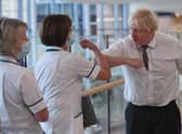 A maskless Boris Johnson greets nurses at Hexham General Hospital in Northumberland during a visit. (Credit: Getty)