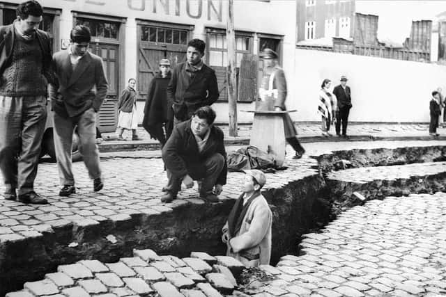 Picture taken in April 1960 in Valdivia of people looking at an enormous crack on a street due to the earthquake that struck the area on May 22, 1960 (Photo: STF/AFP via Getty Images)