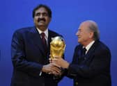 Emir of the State of Qatar Sheikh Hamad bin Khalifa Al-Thani (L) receives the World Cup trophy from Fifa President Joseph Blatter (R) after the official announcement that Qatar will host the 2022 World Cup 