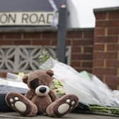 Flowers and teddy bears have been laid at the scene of the house fire that killed two children (image: PA)