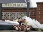 Flowers and teddy bears have been laid at the scene of the house fire that killed two children (image: PA)