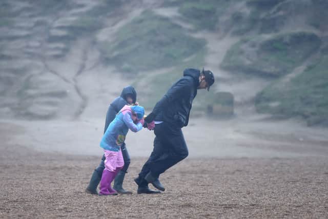 A man and children walk against the wind as storm batters the UK (Photo: Finnbarr Webster/Getty Images)
