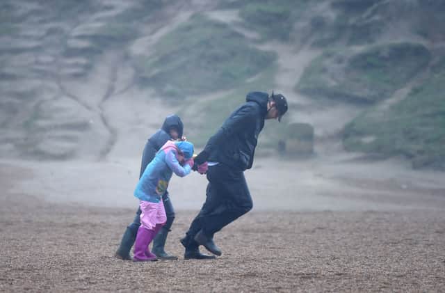 A man and children walk against the wind as storm batters the UK (Photo: Finnbarr Webster/Getty Images)