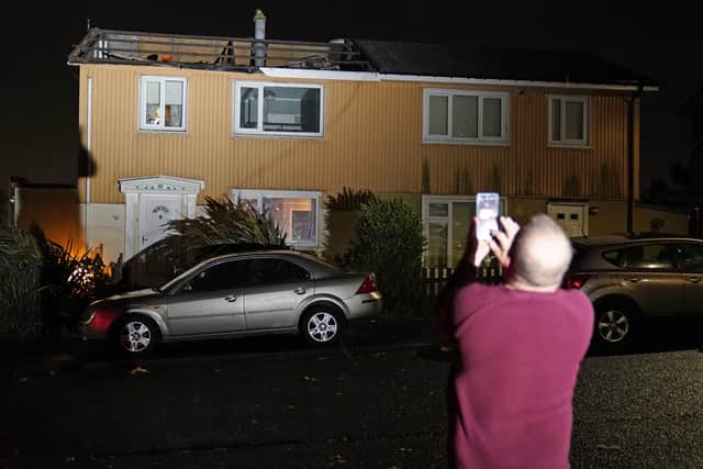 A homeowner, who lost the roof of his house in strong winds, takes a picture of his property in Blackhall, County Durham