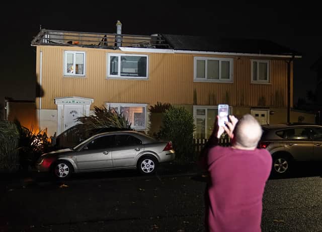 A homeowner, who lost the roof of his house in strong winds, takes a picture of his property in Blackhall, County Durham