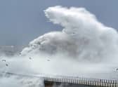 Huge waves crash against the sea wall and Roker Lighthouse in Sunderland