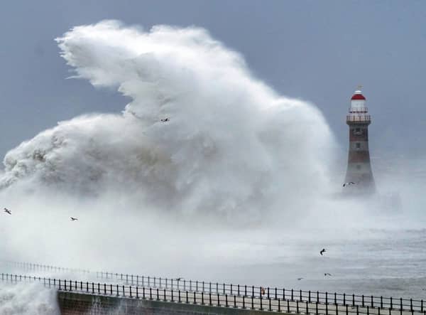 Huge waves crash against the sea wall and Roker Lighthouse in Sunderland