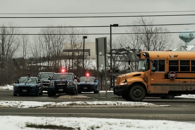 Police cars restrict access to Oxford High School following a shooting 