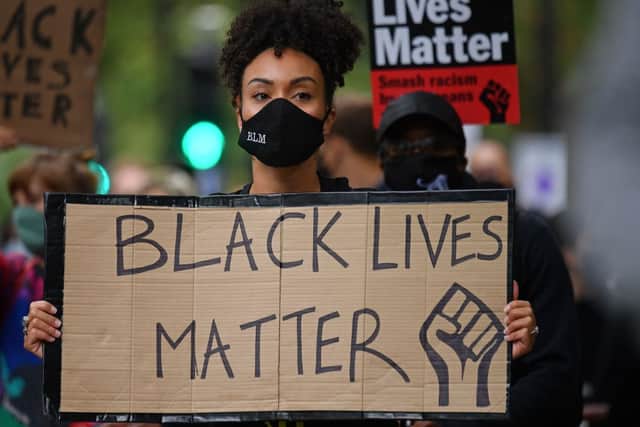 People hold up placards in support of the Black Lives Matter movement as they take part in the inaugural Million People March march (Photo: JUSTIN TALLIS/AFP via Getty Images)