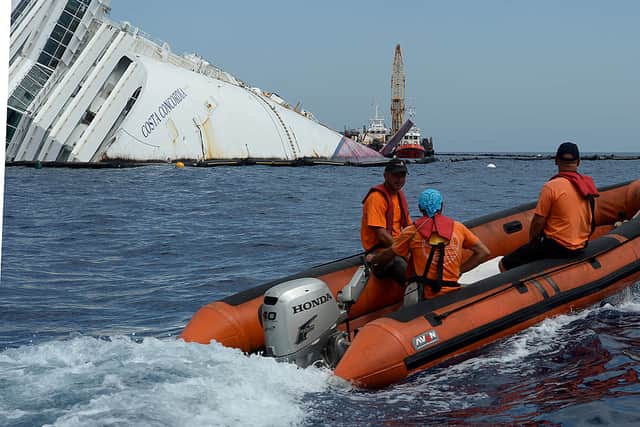Salvage team members work at the rock on the side of the Costa Concordia cruise ship near the harbour of Giglio Porto, six months after the disaster 