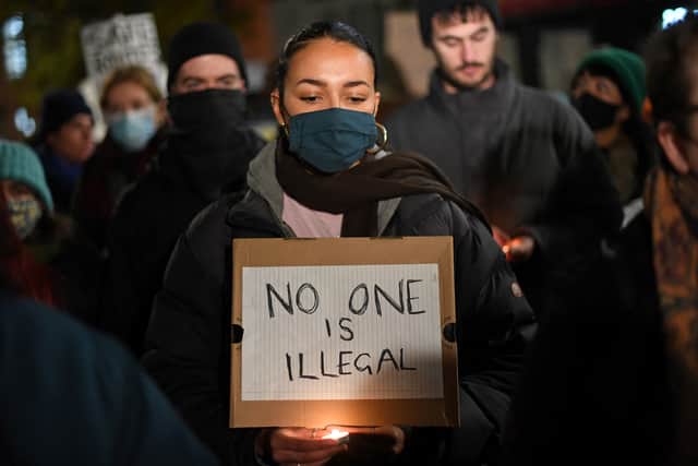 Protestors hold placards as they demonstrate against the Government’s policy on immigration and border controls, outside of the Home Office on November 25 following the death of 27 migrants crossing the English Channel  (Photo by Daniel Leal/AFP via Getty)