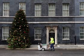 A City of Westminster worker cleans the street in front of 10 Downing Street, the official residence of Prime Minister, Boris Johnson, in central London on December 8, 2021.