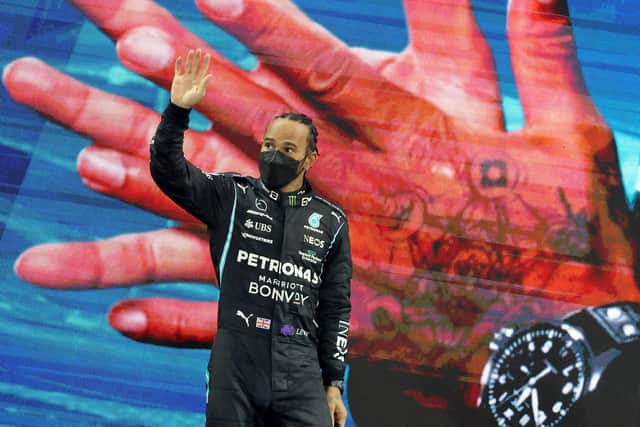 Lewis Hamilton waves on the podium of the Yas Marina Circuit (Photo: Getty)