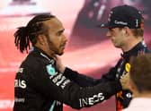 Race winner and 2021 F1 World Drivers Champion Max Verstappen of Netherlands and Red Bull Racing is congratulated by runner up in the race and championship Lewis Hamilton of Great Britain and Mercedes GP during the F1 Grand Prix of Abu Dhabi at Yas Marina Circuit on December 12, 2021 in Abu Dhabi, United Arab Emirates. (Photo by Lars Baron/Getty Images)
