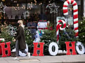 A woman wearing a facemask walks past Christmas decorations outside a wine shop in Mayfair in November 2020 (Photo: Dan Kitwood/Getty Images)