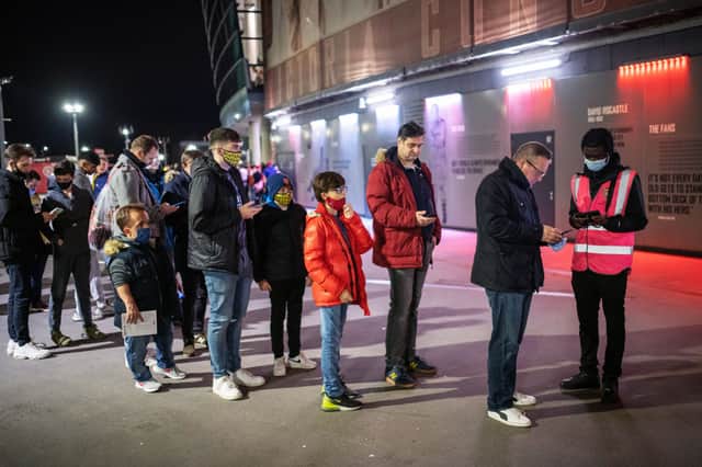 Arsenal fans show their COVID-19 passes as part of the matchday protocols outside the Emirates Stadium. (Photo by Justin Setterfield/Getty Images)