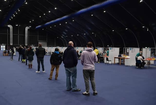 <p>Members of the public await their turn to be vaccinated at the Titanic Exhibition Centre which has been transformed into a vaccination as it opens on December 21, 2021 in Belfast (Photo: Getty)</p>