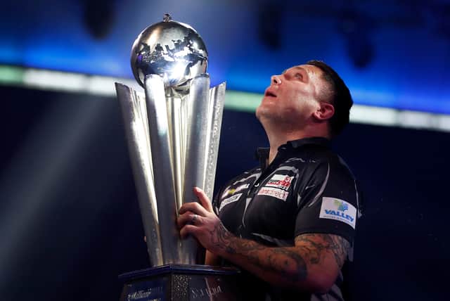 <p>Gerwyn Price of Wales poses with the trophy during the Finals against Gary Anderson of Scotland during Day Sixteen of The PDC William Hill World Darts Championship at Alexandra Palace on January 03, 2021</p>